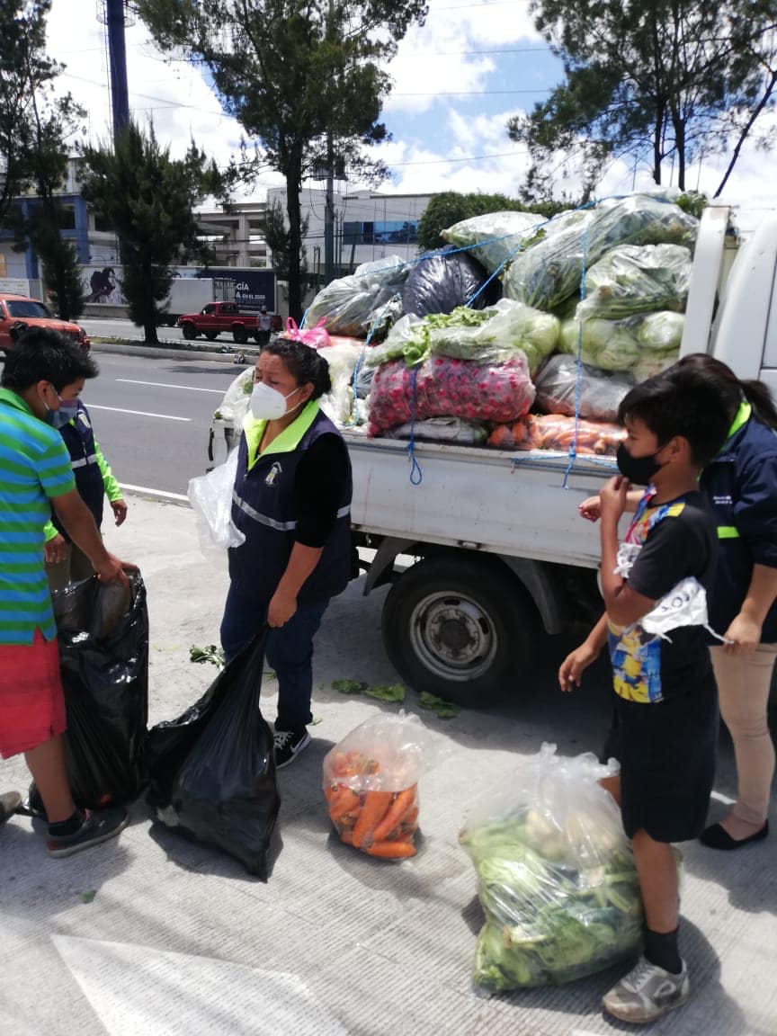 Vecinos de Mixco con banderas blancas reciben raciones de verduras