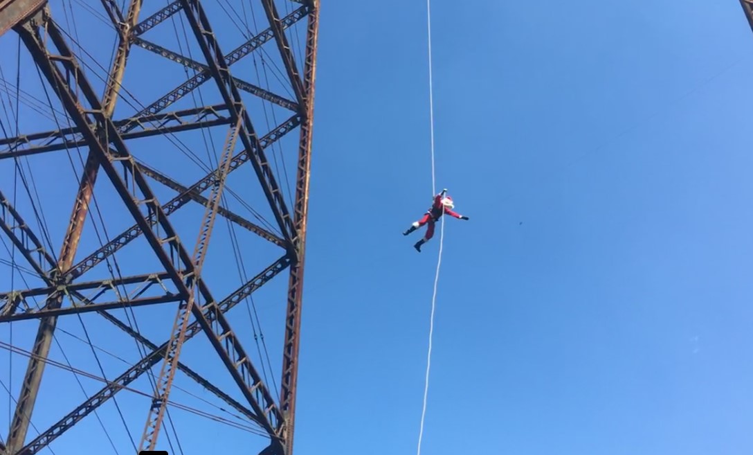 bombero vestido de Santa Claus desciende del puente Las Vacas