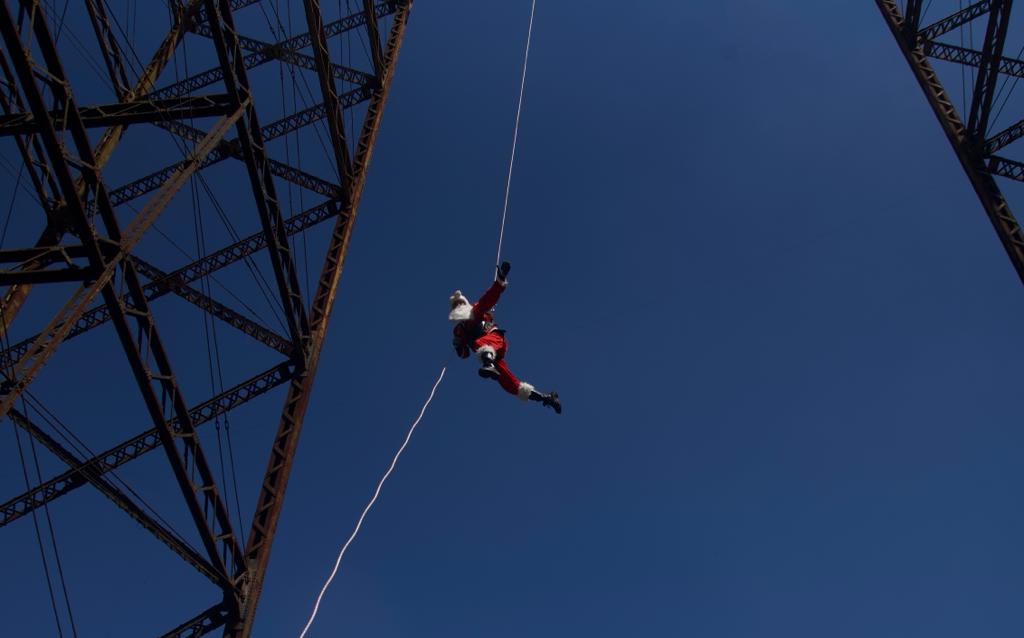 bombero vestido de Santa Claus desciende del puente Las Vacas