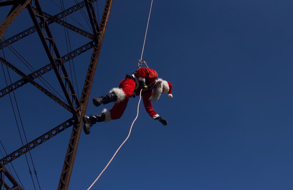 bombero vestido de Santa Claus desciende del puente Las Vacas