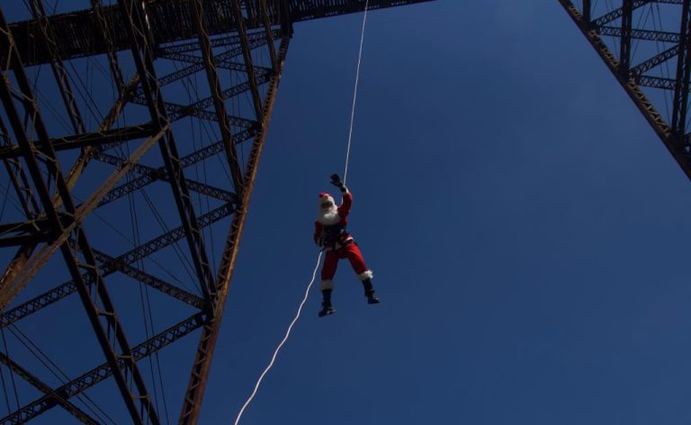 bombero vestido de Santa Claus desciende del puente Las Vacas