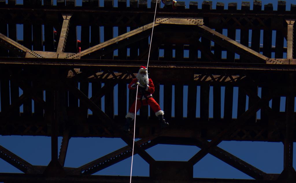 bombero vestido de Santa Claus desciende del puente Las Vacas