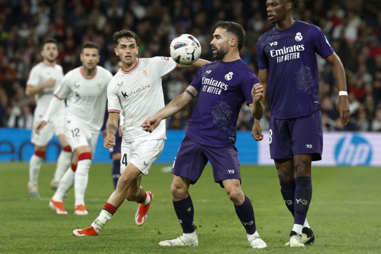 MADRID, 31/03/2024.- El defensa del Real Madrid Dani Carvajal (c) disputa un balón ante el centrocampista Beñat Prados (i), del Athletic Club, durante el partido de la jornada 30 de LaLiga que Real Madrid y Athletic Club de Bilbao disputan hoy domingo en el estadio Santiago Bernabéu, en Madrid. EFE/ Chema Moya