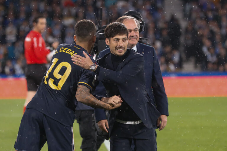 SAN SEBASTIÁIN, 26/04/2024.- El delantero de la Real Sociedad Sadiq Umar (i) saluda a David Silva, antes del partido de Liga en Primera División que Real Sociedad y Real Madrid disputan este viernes en el Reale Arena, en San Sebastián. EFE/Juan Herrero