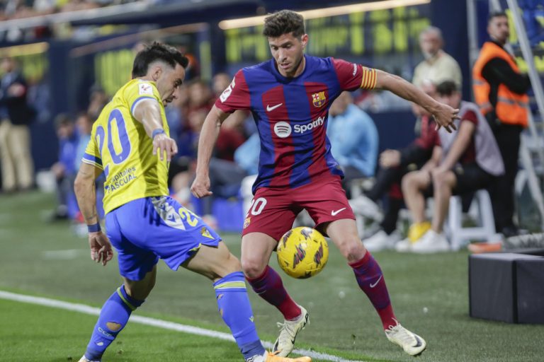 CÁDIZ, 13/04/2024.- El centrocampista del FC Barcelona Sergi Roberto (d) lucha por el balón con el defensa del Cádiz CF Iza (i) durante el partido de Liga que enfrenta al Cádiz CF y al Barcelona CF en el estadio Nuevo Mirandilla, este sábado. EFE/Román Ríos